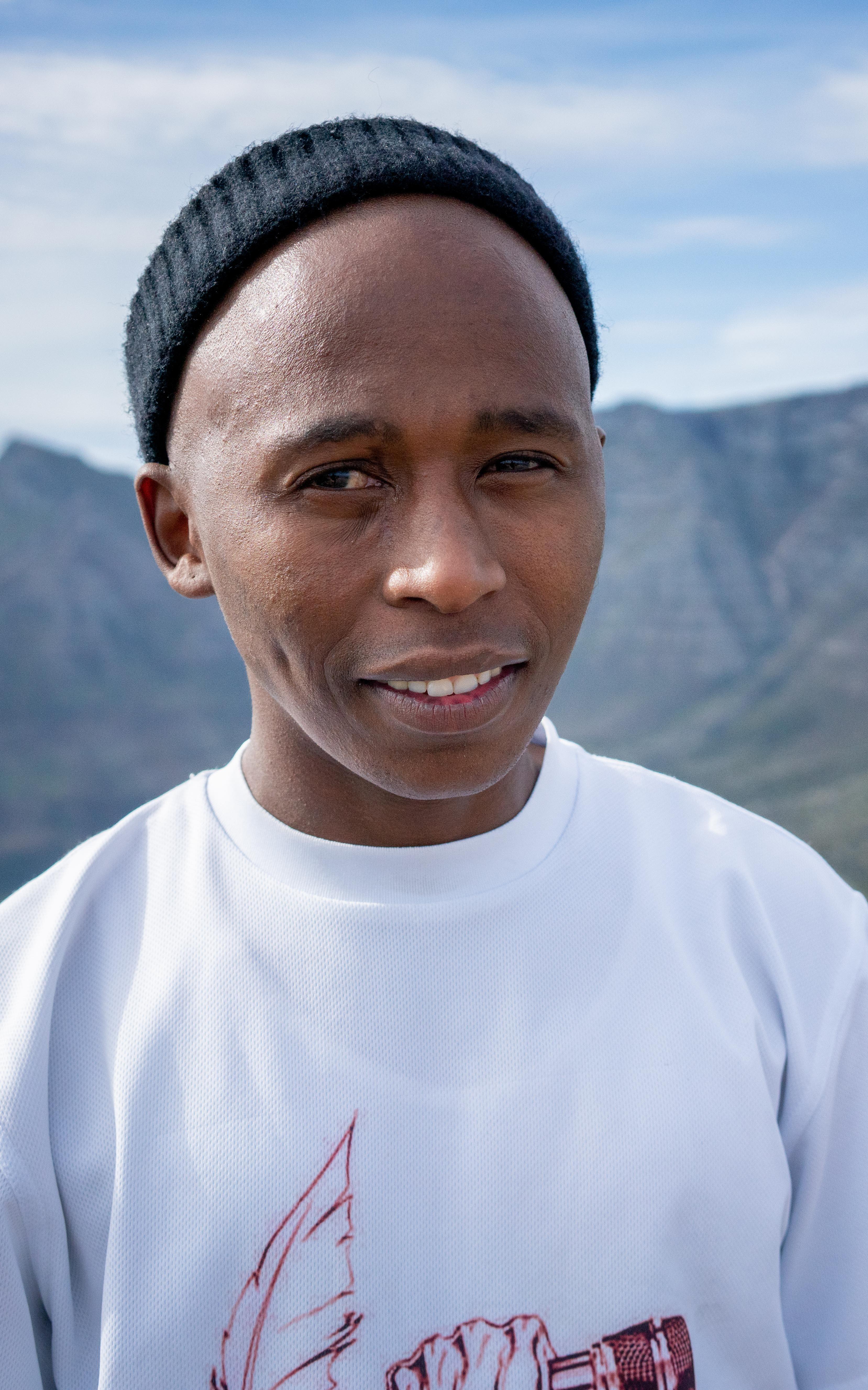 Beautiful News - Sakhiwo Ndawose of Blazing Pens Cypher Hikes stands with Table Mountain behind him