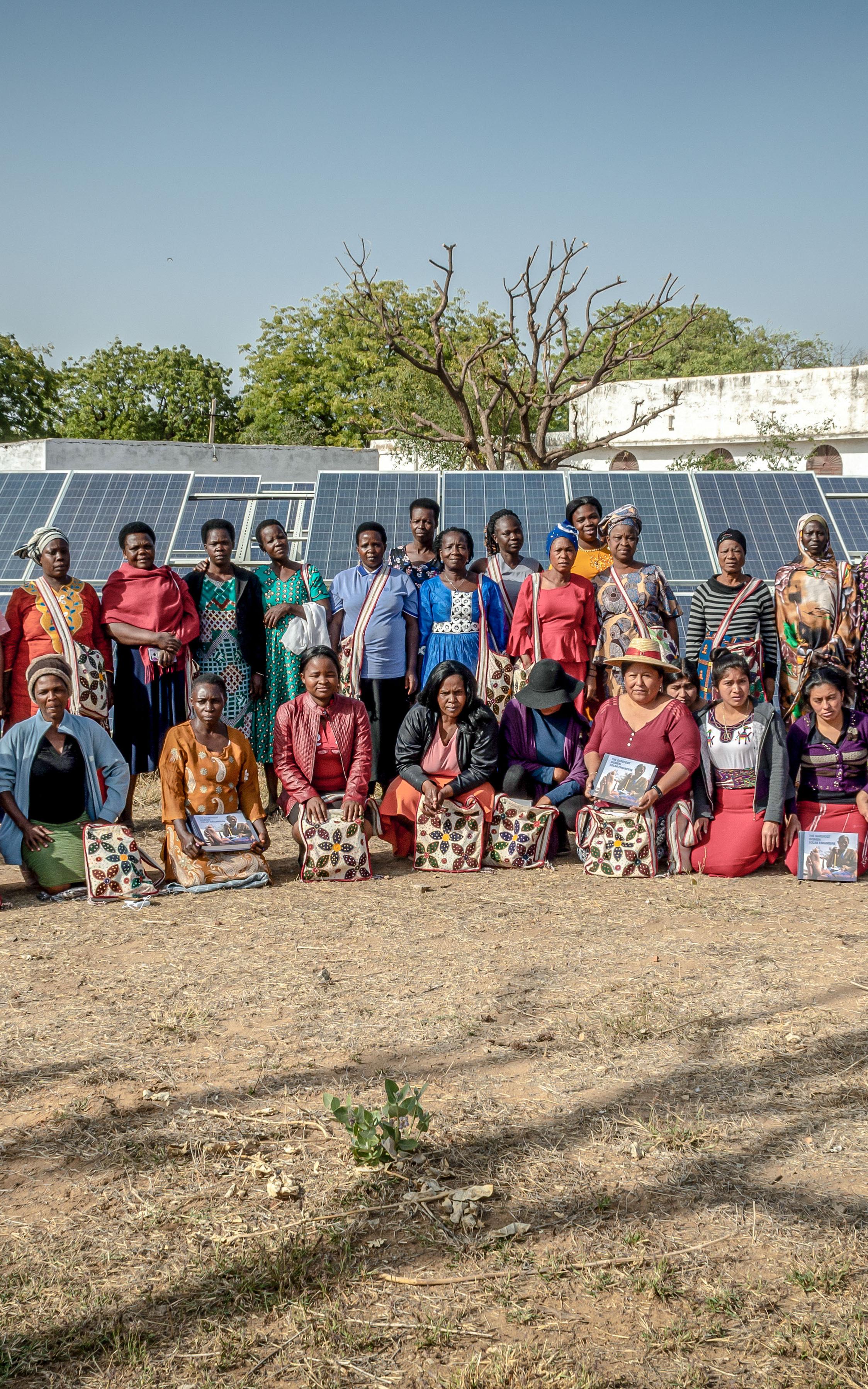 Beautiful News-Women standing in front of solar panels.