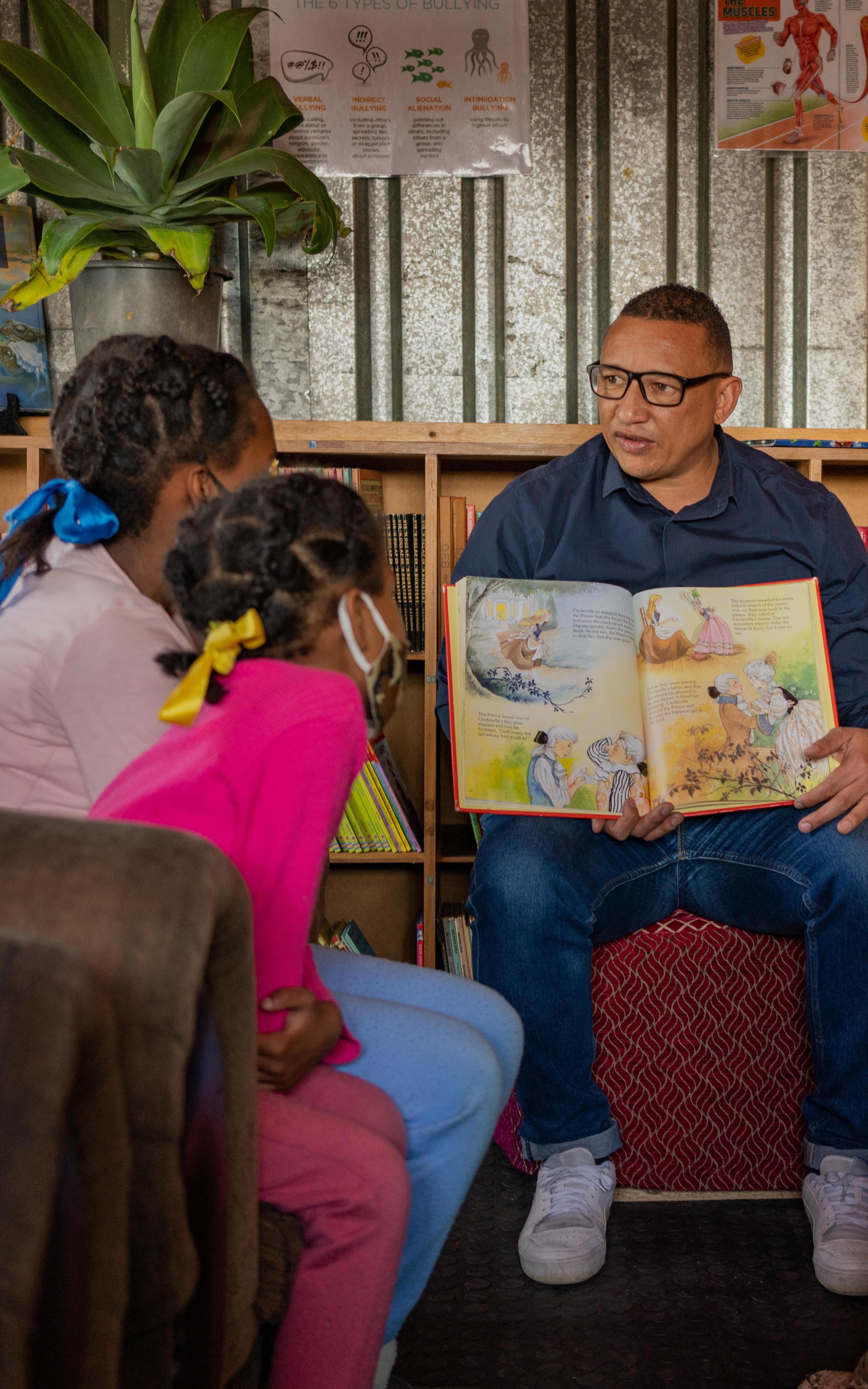 Beautiful News - Terence Crowster of Hot-Spot Library reading a children's book to a group of interested youngsters
