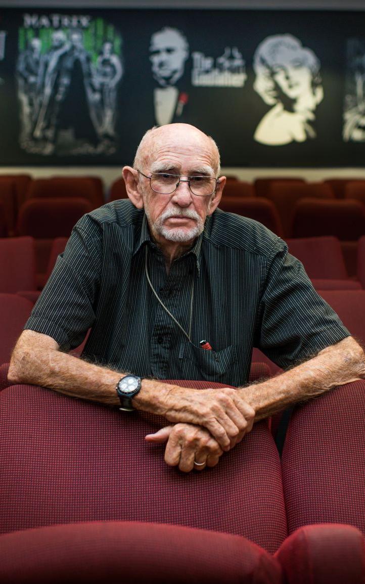 Old white man sitting in the cinema.