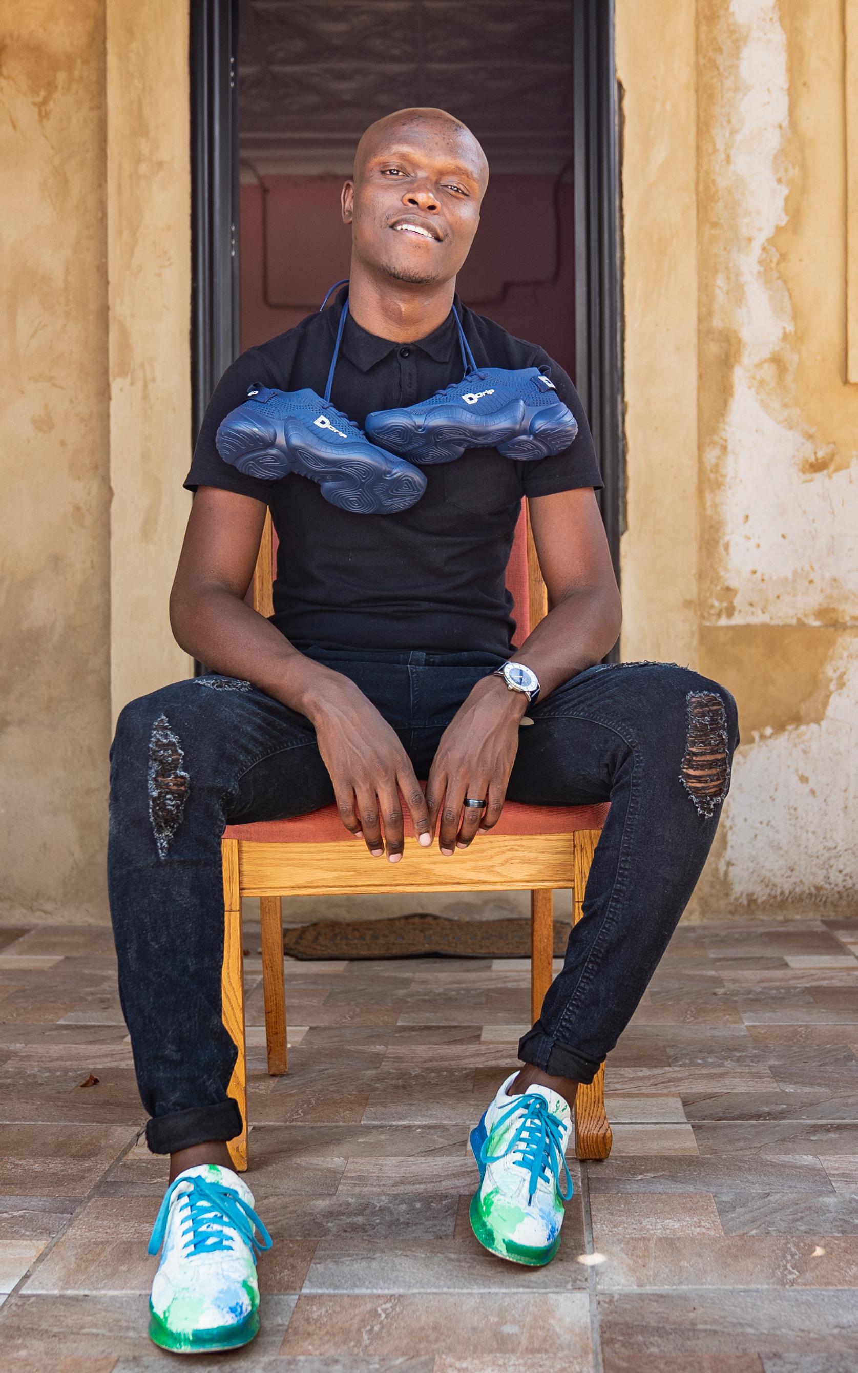 Black man sitting on chair on porch.