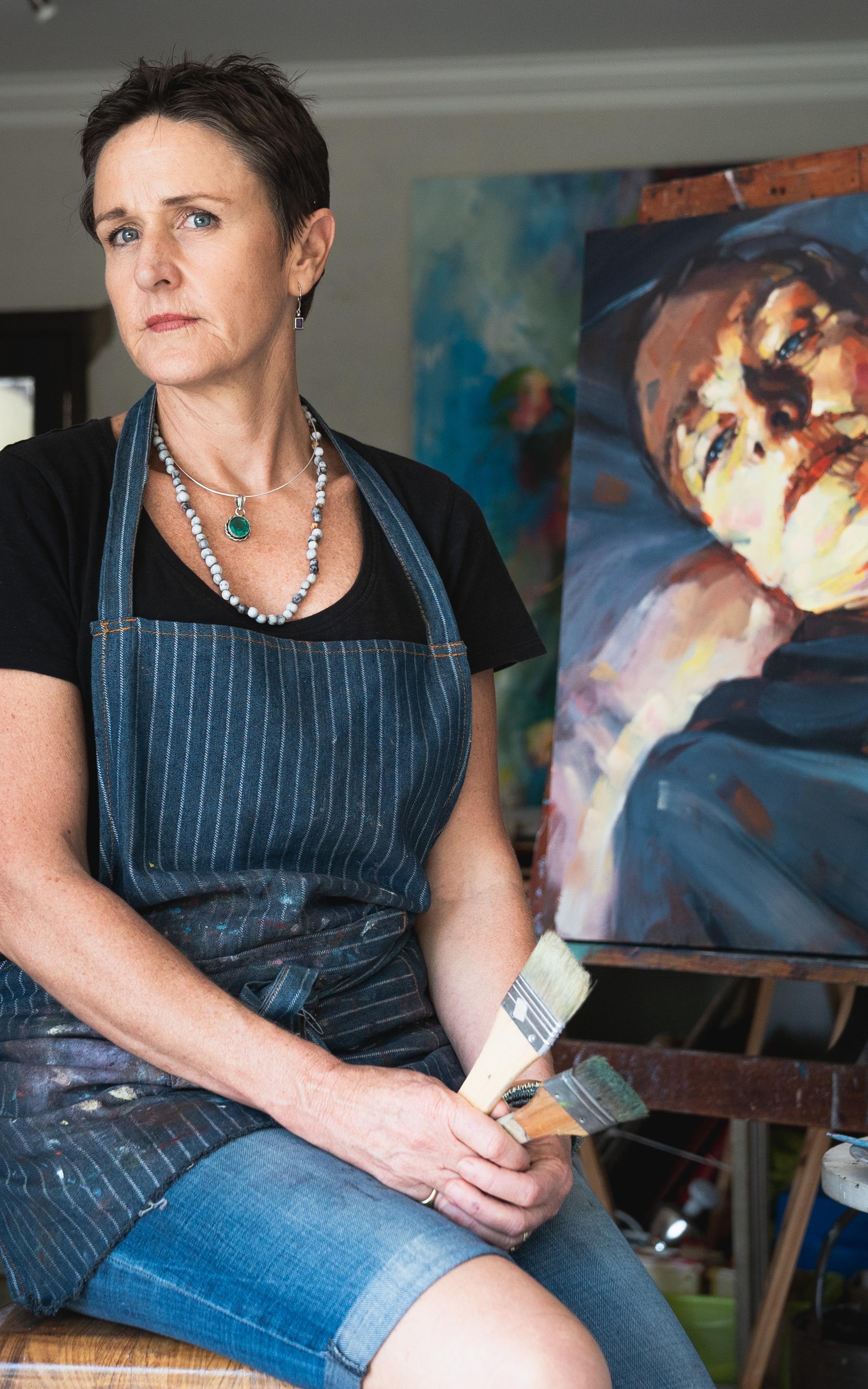 Artist in front of a painting.