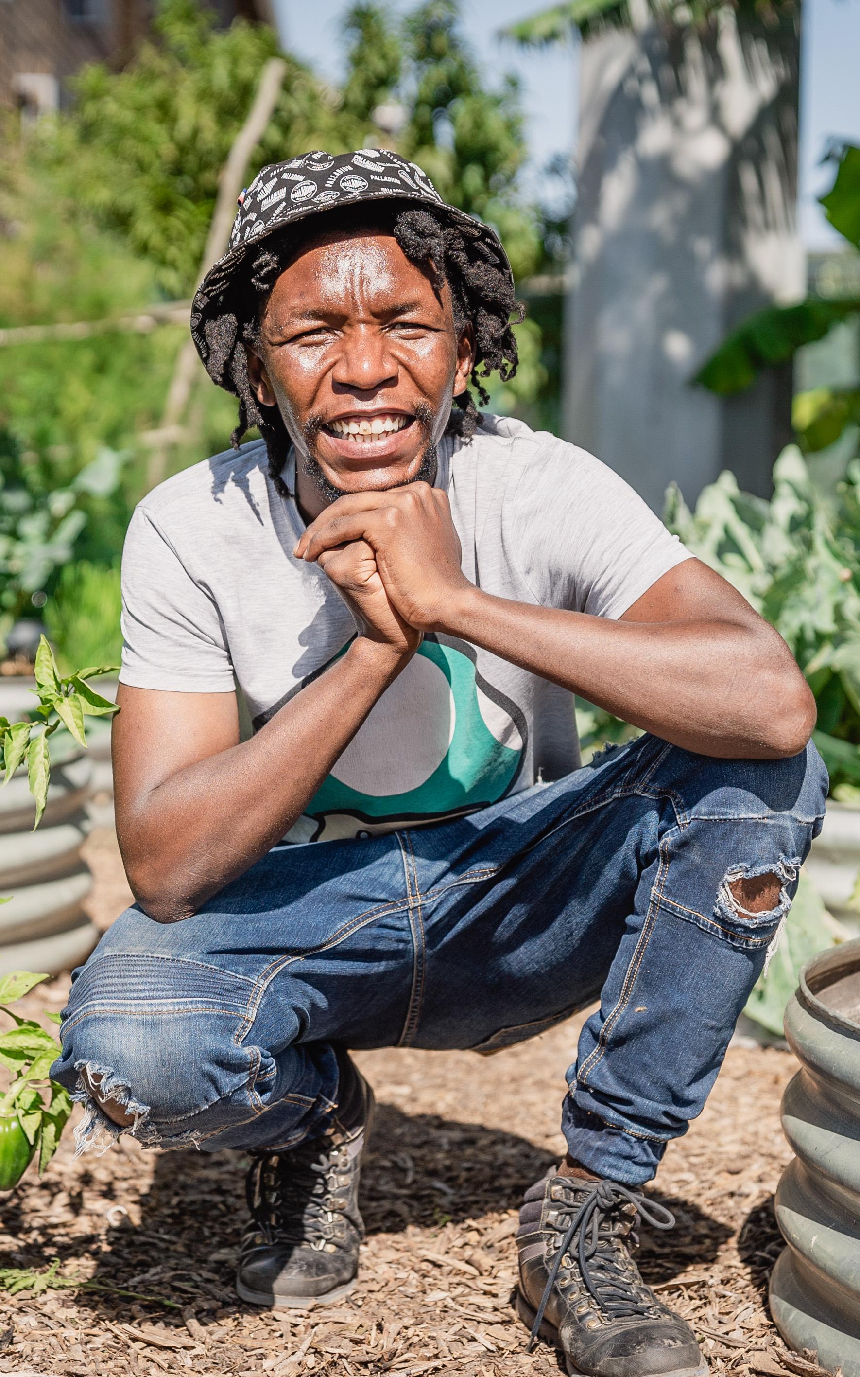 Gardener kneeling next to plants