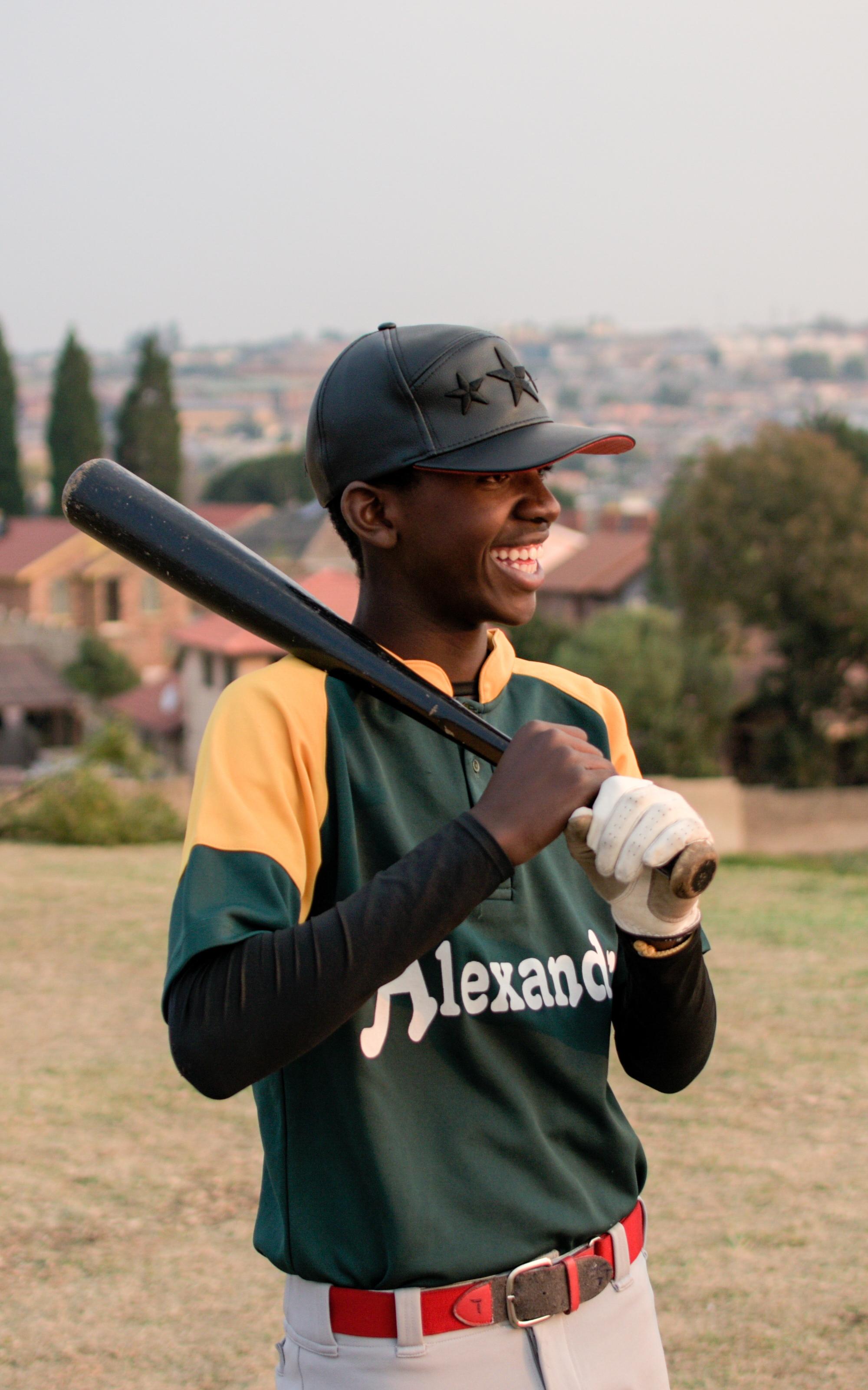 Boy smiling holding a baseball bat