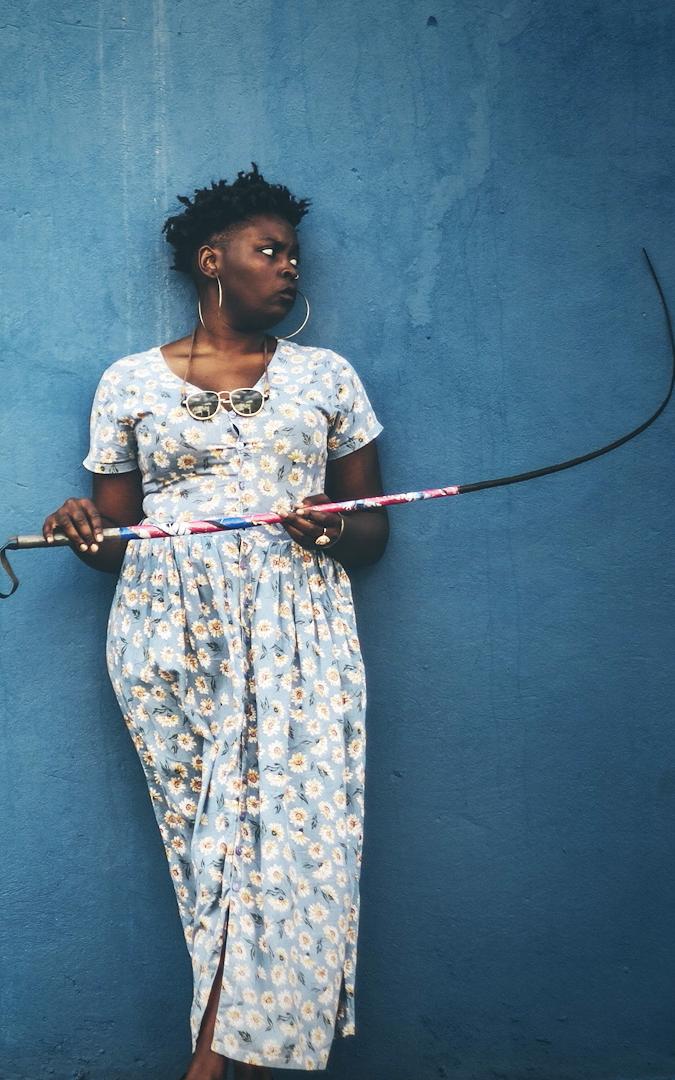 African woman holding a stick looking off to the side