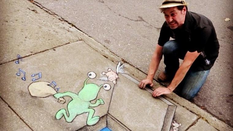 Man with drawing on the sidewalk. 