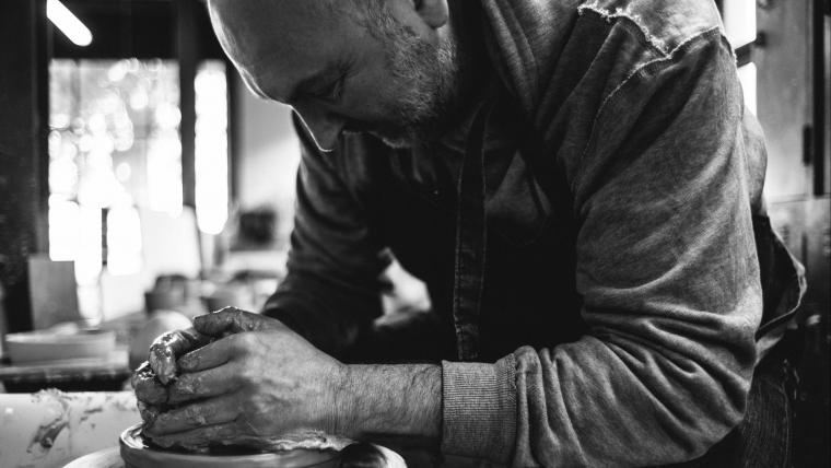 Ceramicist working on his pottery wheel.