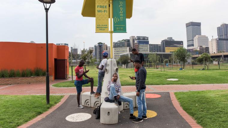 Teenagers sitting on WIFI bench