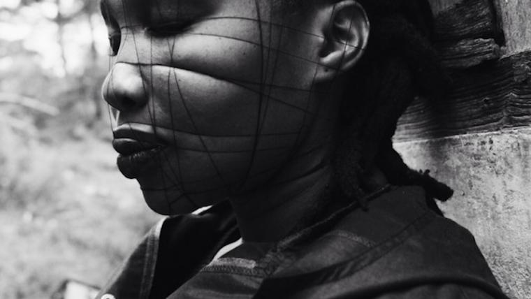 Black model with string on her face.