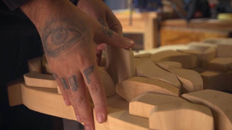 Tattooed hands holding wooden blocks