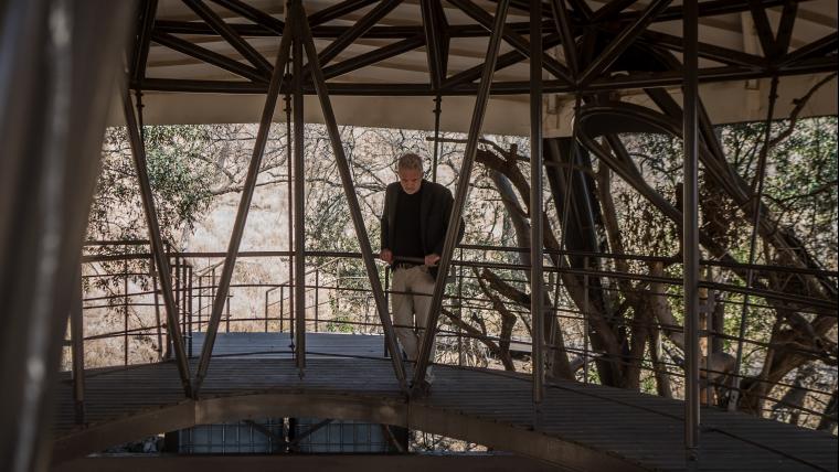 Man looks down while standing in a wooden structure