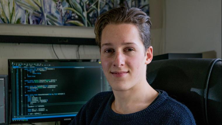 Teenager smiling in front of computer