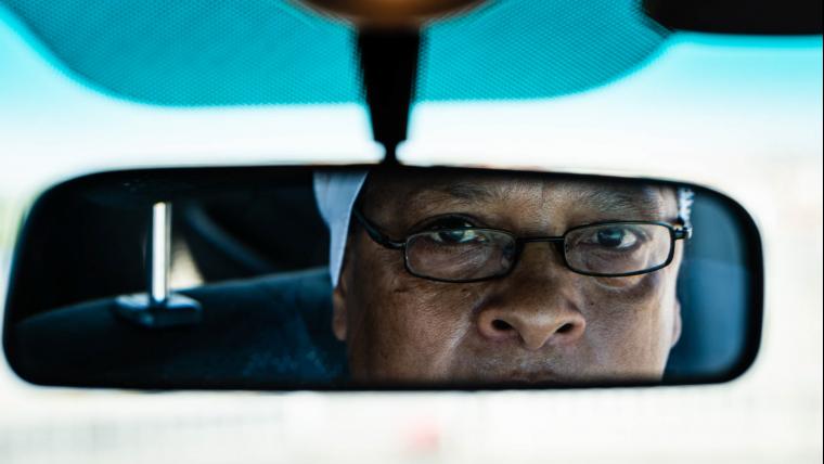 Woman looking in rearview mirror