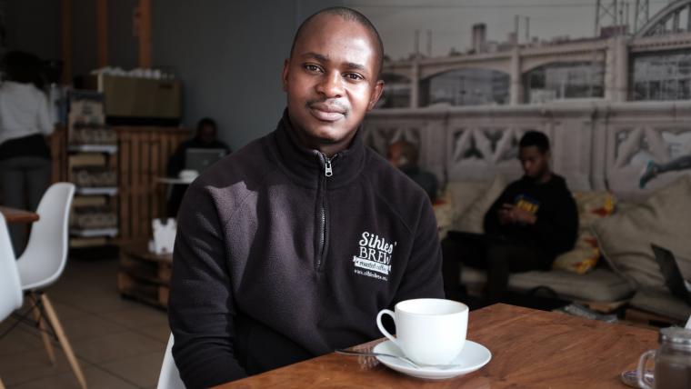 Black man smiling with coffee cup