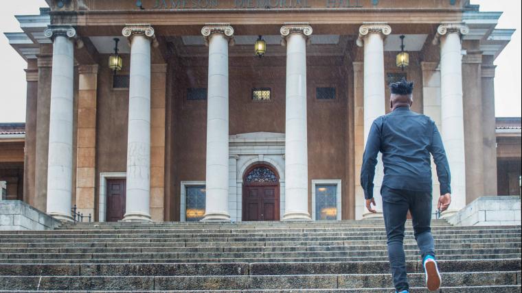 Man walks up stairs towards UCT's main hall