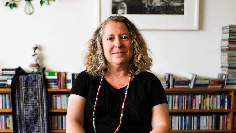 Woman sits in front of a bookshelf