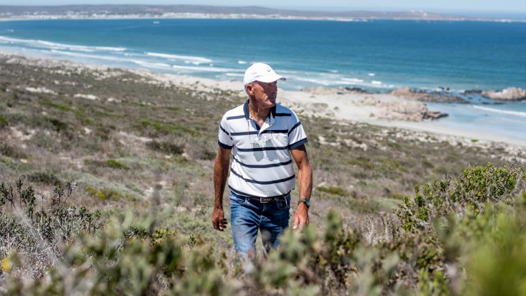 Man walking with ocean behind him