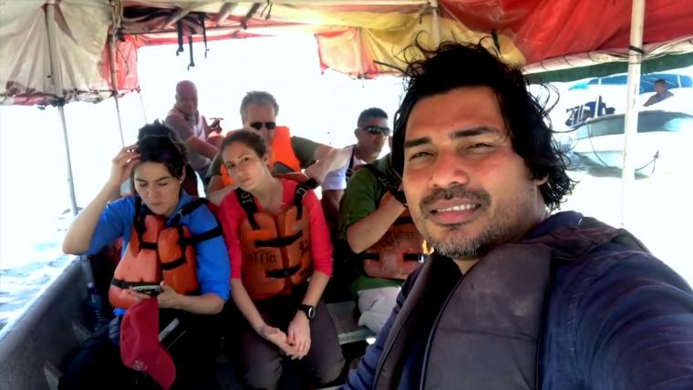 Beautiful News - Man taking a selfie with others on a boat.