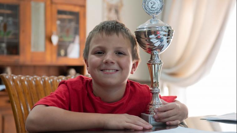 Kid posing with trophy