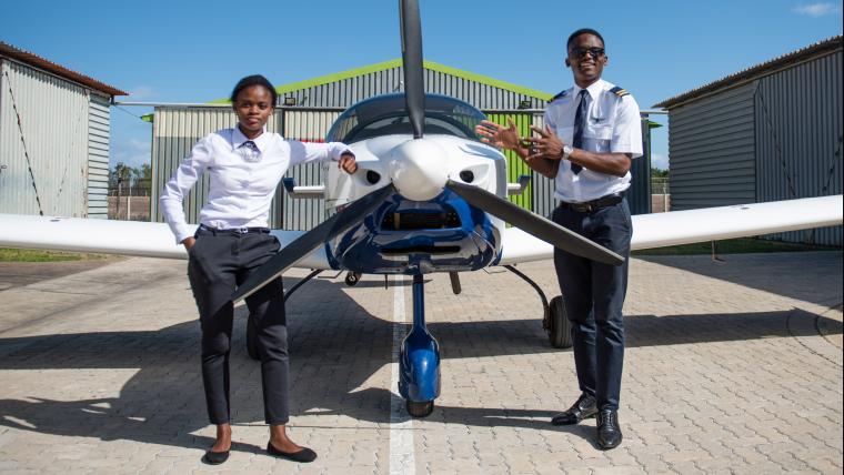 Two pilots standing in front of plane