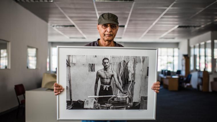 Photographer holding a framed photo he took.