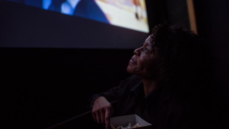 Woman smiling while looking up at a cinema screen