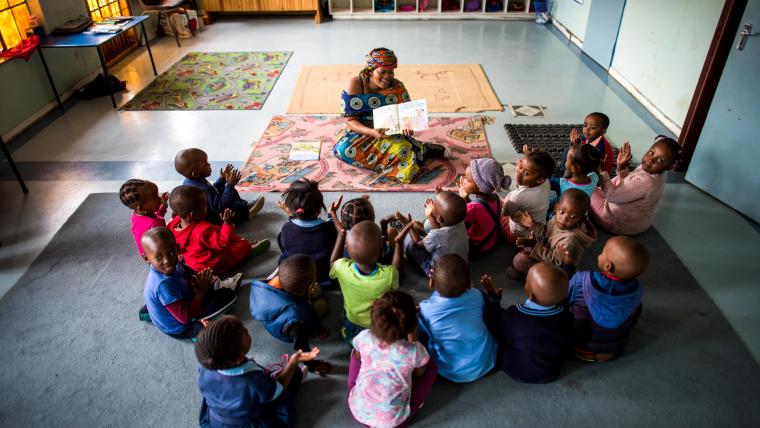 Woman reads to children. 