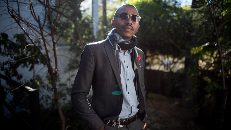 Fashionably dressed black man smiling at camera