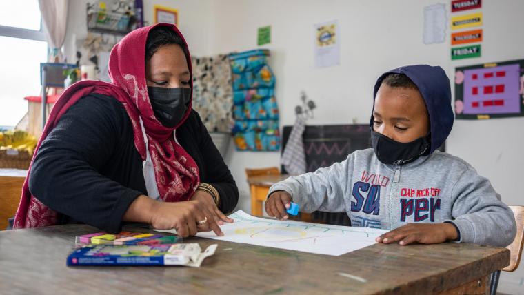 Beautiful News-Masked woman and child looking at drawing