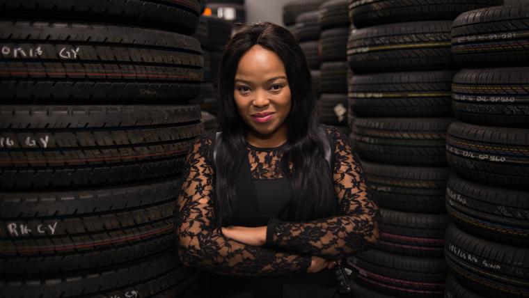 Woman standing between car tyres 