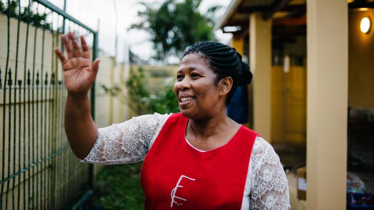 Black woman smiling and waving