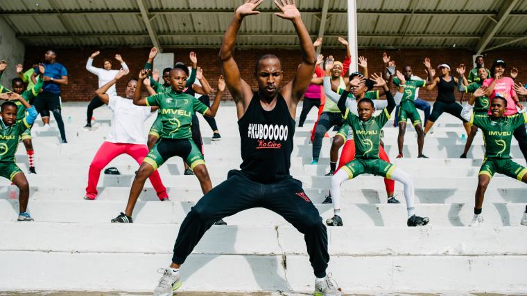 Man instructing children on how to do exercise