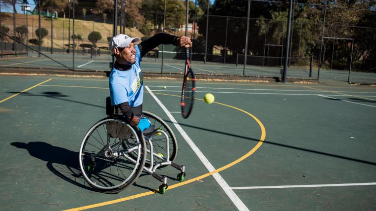 Man in a wheelchair plays tennis