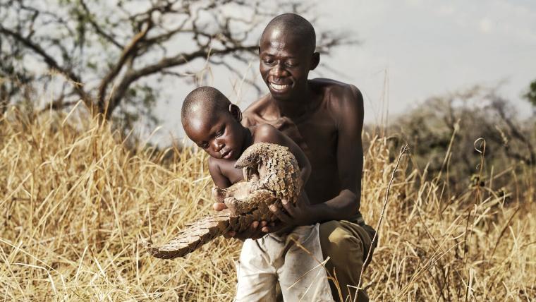 Father and son holding pangolin