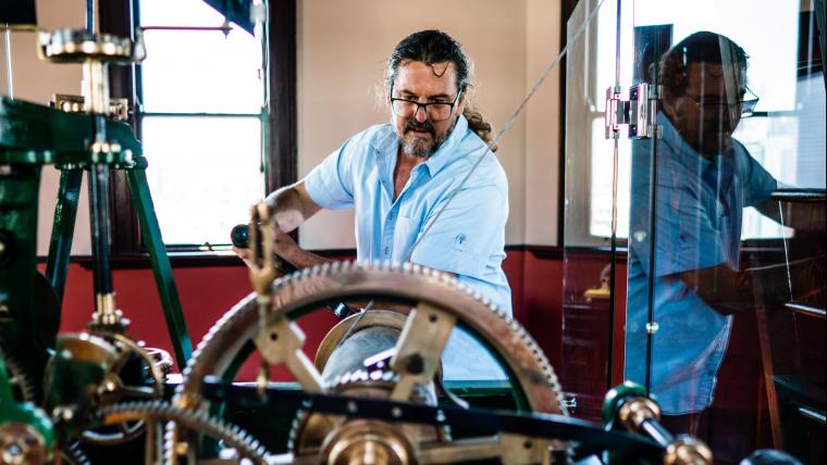 Man working on clock tower gears.