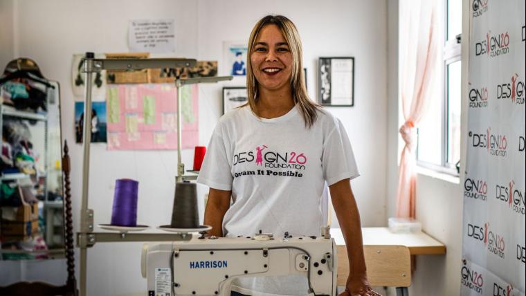 Coloured woman standing behind sewing machine