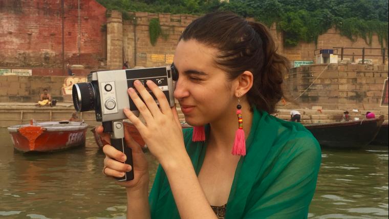 Woman looking through vintage video camera