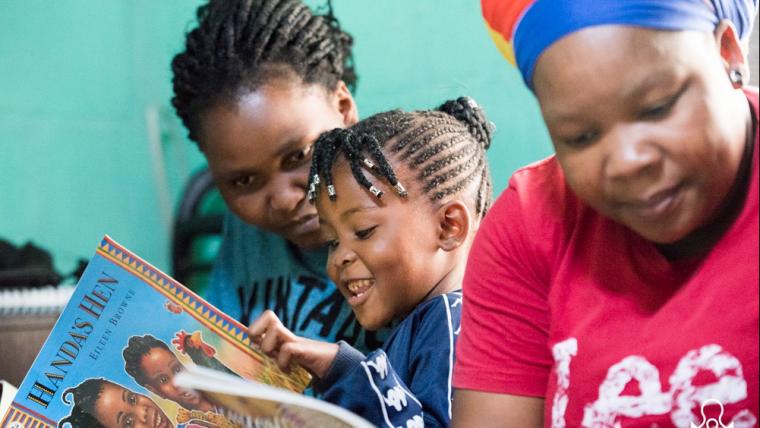 Kids looking at a book.