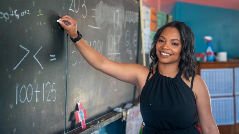 Cape Town teacher Keachell Jeffery writes out a maths sum on a classroom chalkboard