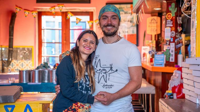 Beautiful News-Couple holding hands in a restaurant kitchen.