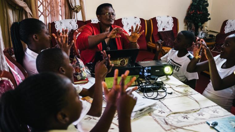 woman with projector teaching kids.