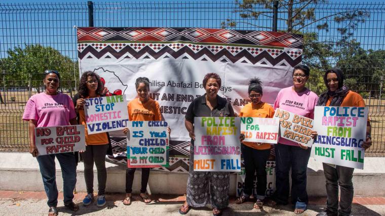 Group of woman standing with signs.