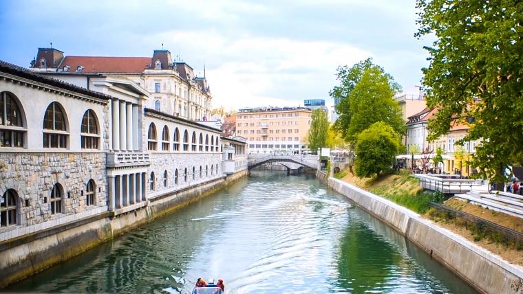 Beautiful News - Image of people on a boat travelling through a water canal in Ljubljana, Slovenia.
