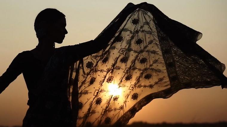 Beautiful News - Lady standing as silhouette against backdrop of sun in Varanasi India