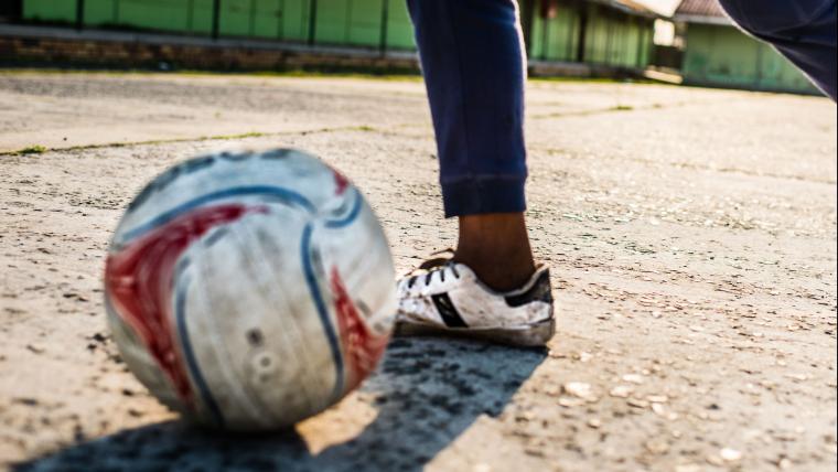 Soccer ball and boy wearing soccer shoes