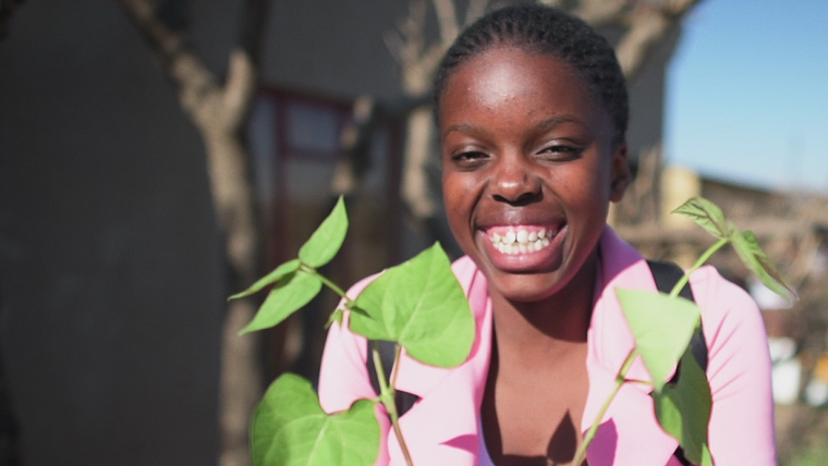 Smiling girl. Plant.