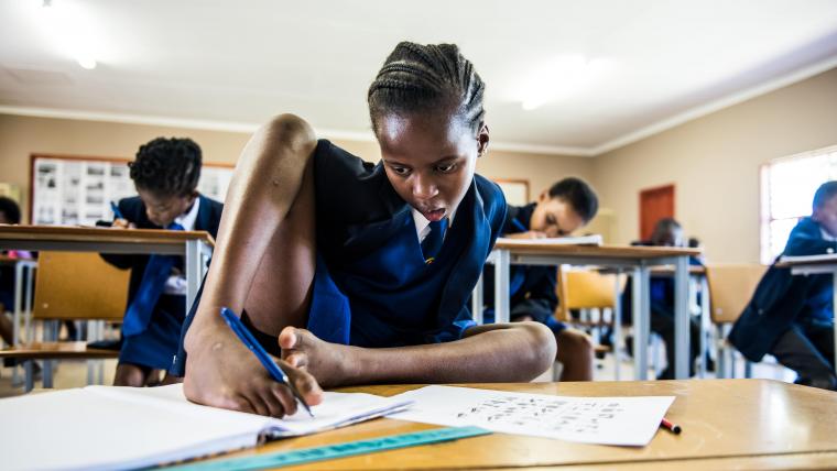 Girl writing with foot