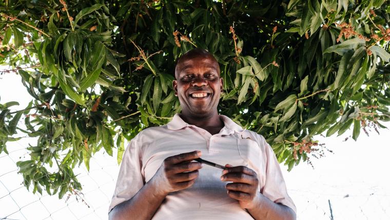 Black man smiling under tree