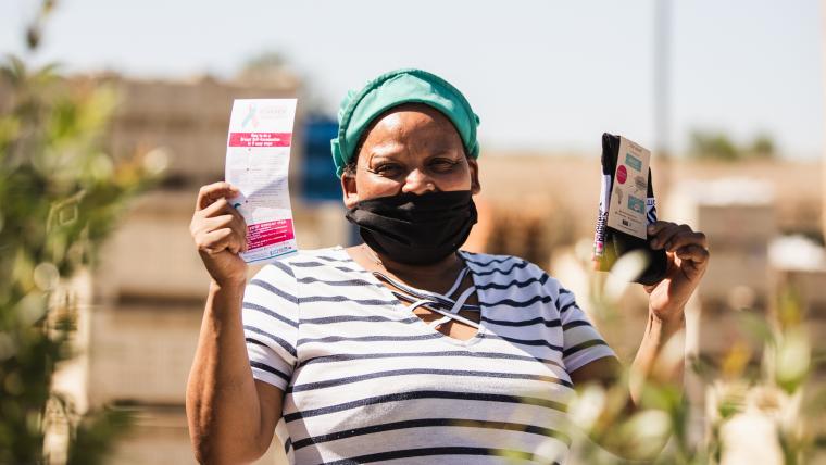 Beautiful News - A lady holds up pairs of socks that support breast cancer awareness