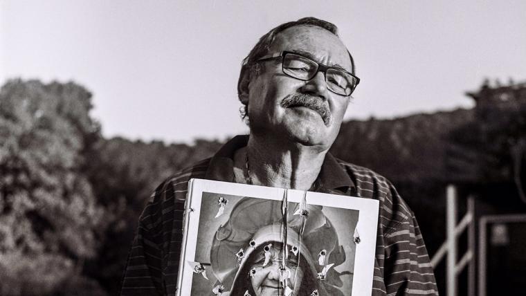 Photographer holding up photo album.